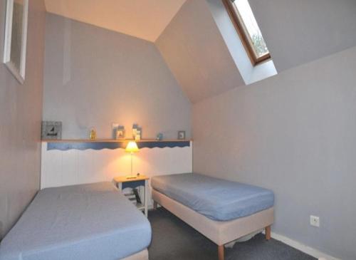 une chambre avec deux lits et une table avec une lampe dans l'établissement Maison Fort Mahon Belle Dune Village Vacances, à Fort-Mahon-Plage