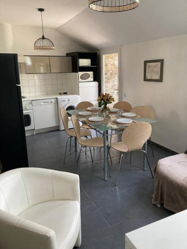 une cuisine et une salle à manger avec une table et des chaises dans l'établissement Les Herbes Maritimes Gîte, à Hirel