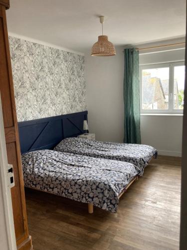 a bedroom with a bed and a window at Les Herbes Maritimes Gîte in Hirel