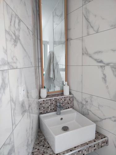 une salle de bain blanche avec un lavabo et un miroir dans l'établissement Maison de vacances ile d'Oléron 4 pers à St Denis proche plage, à Saint-Denis-dʼOléron