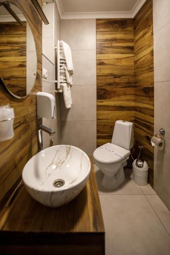 a bathroom with a sink and a toilet at Sunny Hotel in Lviv