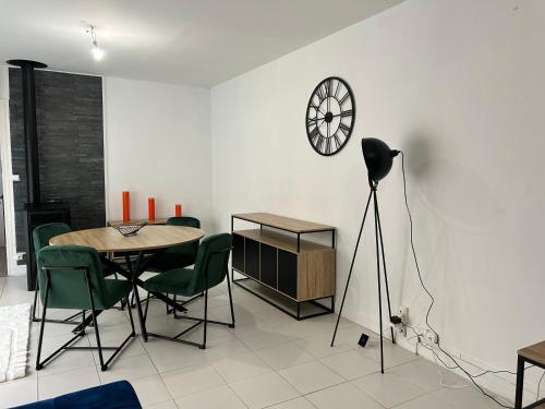 une salle à manger avec une table et une horloge au mur dans l'établissement La Perle Rive Gauche, au Mans