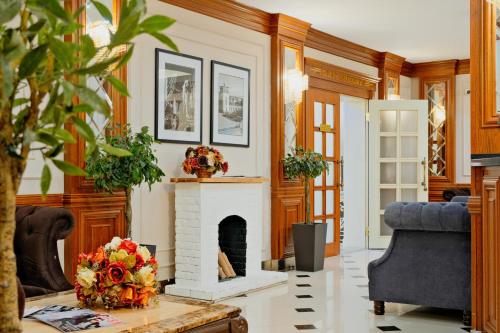 a living room with a fireplace and a couch at ATB Grand Hotel in Atyrau