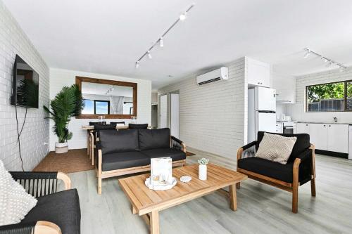 a living room with a couch and a table at Salt & Stone Villa on the beach - Villa 2 in Burrum Heads