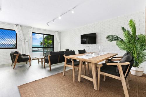 a living room with a wooden table and chairs at Salt & Stone Villa on the beach - Villa 2 in Burrum Heads
