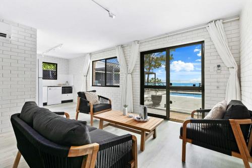 a living room with two couches and a table at Salt & Stone Villa on the beach - Villa 2 in Burrum Heads