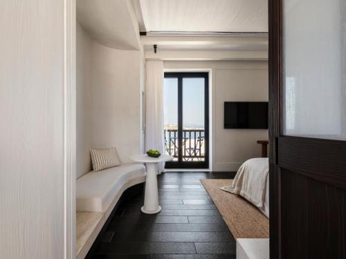 a room with a bed and a table and a television at Anandes Hotel in Mýkonos City
