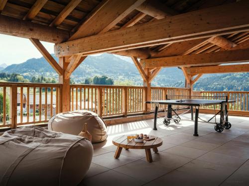 a screened in porch with a ping pong table at La Ferme de Mila - OVO Network in Saint-Jean-de-Sixt