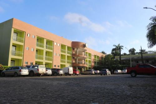 a parking lot with cars parked in front of a building at Hotel Absolar in Alagoinhas