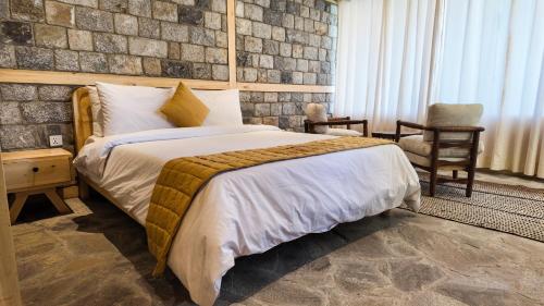 a bedroom with a bed and a stone wall at Dera Lamsa Resort Shigar in Shigar
