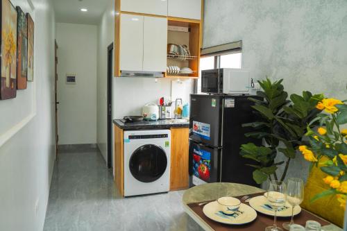 a small kitchen with a refrigerator and a dishwasher at Lilo's Homestay West Lake Thuy Khue in Hanoi
