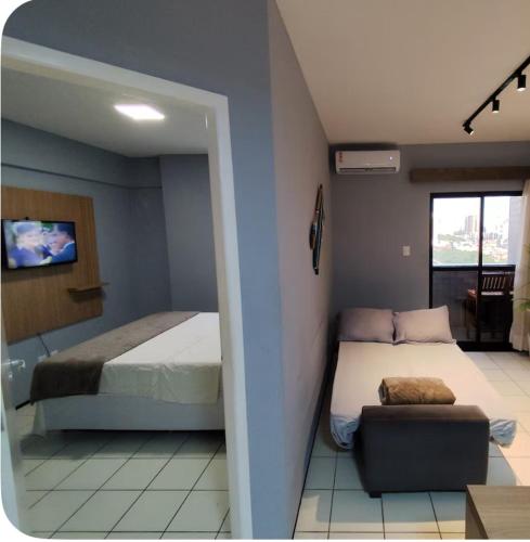 a bedroom with a bed and a couch in it at Flat 706 próximo à praia - Condomínio Biarritz in São Luís