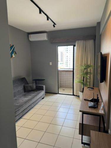 a living room with a couch and a table at Flat 706 próximo à praia - Condomínio Biarritz in São Luís