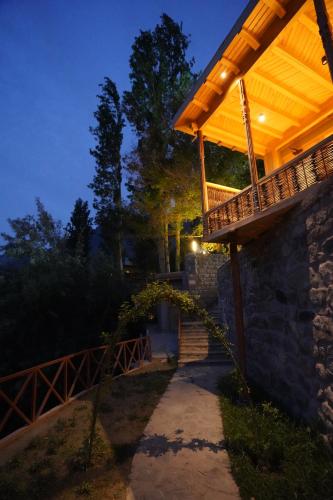 a wooden pergola on the side of a building at Dera Lamsa Resort Shigar in Shigar