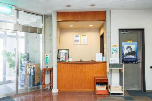 a lobby with a reception desk in a building at ビジネスホテル寿屋 in Handa