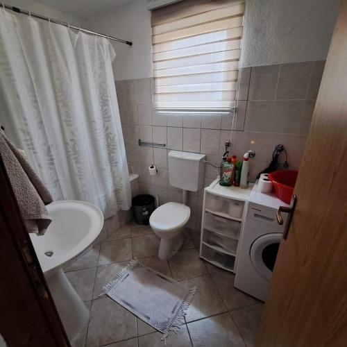ein Badezimmer mit einer weißen Toilette und einem Waschbecken in der Unterkunft Oaza mira BK in Bosanska Krupa