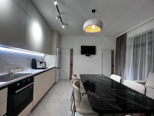 a kitchen with a black counter top and a table at Yssyk-kul Palm in Chok-Tal