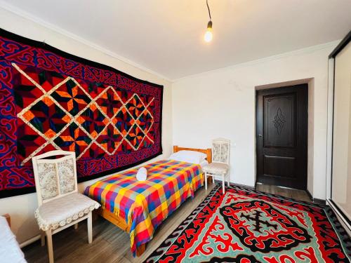 a bedroom with a bed and a colorful rug at DADOW Guesthouse in Naryn