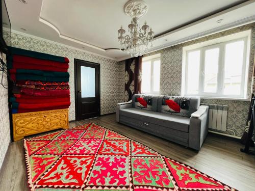 a living room with a couch and a red rug at DADOW Guesthouse in Naryn