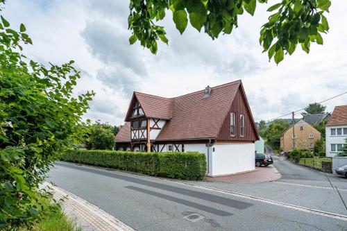 a house with a brown roof on the side of a street at Ferienhaus Oberlausitz mit 160qm in Cunewalde