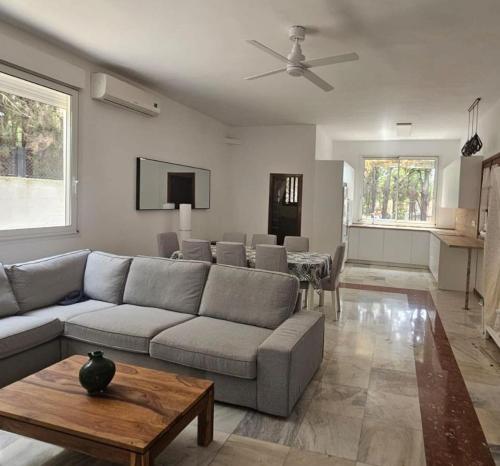 una sala de estar con un sofá y una mesa en Spacious Garden Villa, private pool, huge grounds with orange trees, en Dos Hermanas