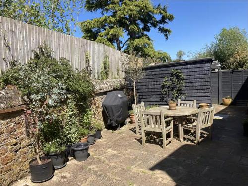 a patio with a table and chairs and a fence at Borough Lee in Midhurst