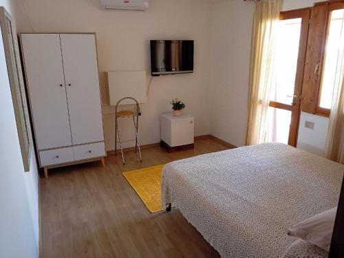 a bedroom with a bed and a white cabinet at Benjamin Room in Olbia