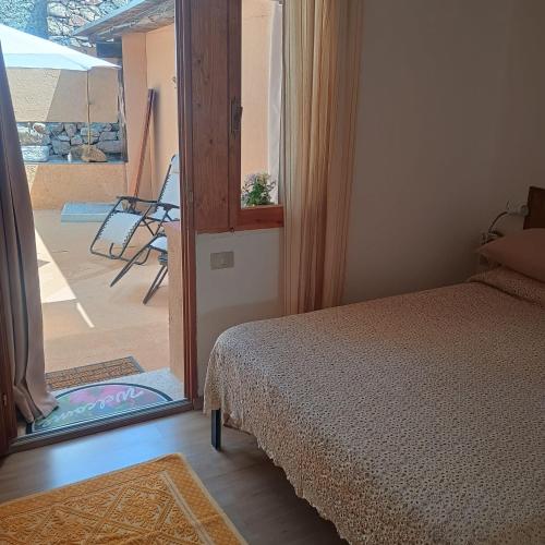 a bedroom with a bed and a door to a patio at Benjamin Room in Olbia