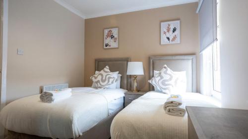 two beds sitting next to each other in a bedroom at Forbes House in Glasgow