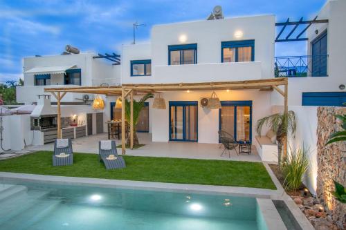 a villa with a swimming pool in front of a house at Sia Villa in Lardos