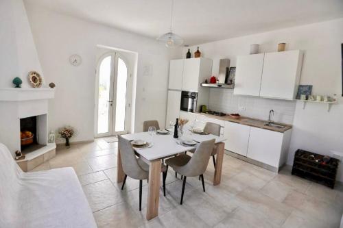 Una cocina y un comedor con mesa y sillas. en Dimora Le Terrazze, en Selva di Fasano