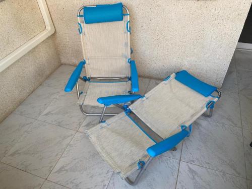 a blue folding chair sitting next to a wall at Apolo XI, Calpe, Modern Holiday Apartment, Sea view, Pool, 100m to Beach! in Calpe