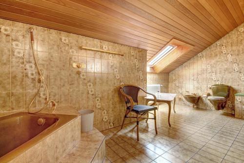 a bathroom with a tub and a table and a toilet at Villa Galerie in Hohenwart