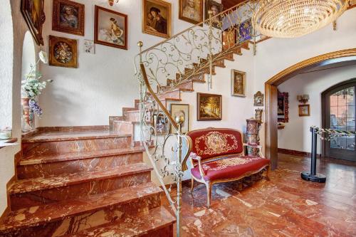 a living room with a staircase and a red chair at Villa Galerie in Hohenwart