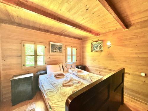 a bedroom with a bed in a wooden cabin at Hotel Oka i Po in Berane