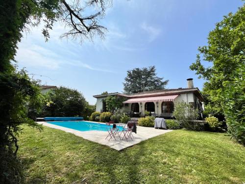 une maison avec une piscine dans la cour dans l'établissement Villa 10 personnes aux pieds des Pyrénées Pau, à Billère