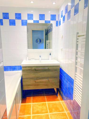 une salle de bain avec un lavabo, un miroir et une baignoire dans l'établissement Les terrasses du Liouquet, à La Ciotat