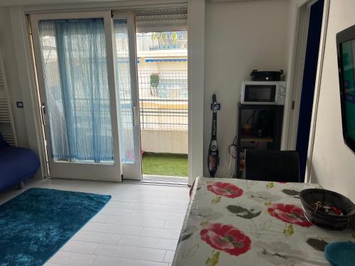 d'un salon avec une table et une porte coulissante en verre. dans l'établissement Studio in cannes Croisette, à Cannes