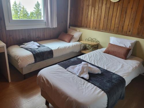 une chambre avec deux lits et une fenêtre dans l'établissement Auberge Restaurant du Virage, à Chamrousse