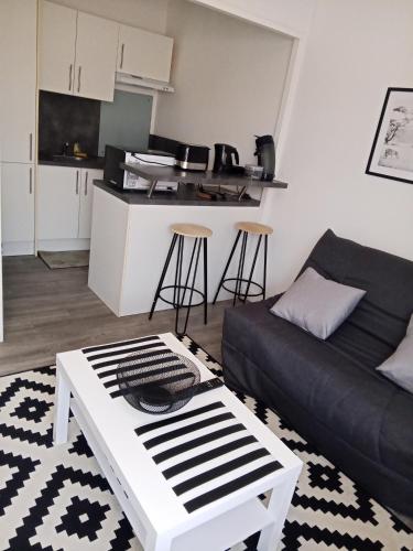 ル・ポンテにあるFurnished studio, 5 min Avignon, Pontet centerのソファとテーブルのあるリビングルーム