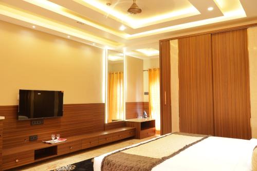 a bedroom with a large bed and a television at Suramya Homestay Near Shymala Hills in Bhopal