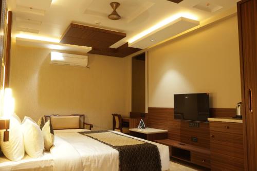 a hotel room with a bed and a flat screen tv at Suramya Homestay Near Shymala Hills in Bhopal