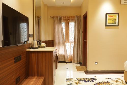 a room with a bed and a tv and a window at Suramya Homestay Near Shymala Hills in Bhopal