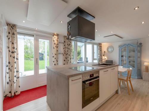 Holiday Home Sint Maartenszee Garden Bliss في Sint Maartensvlotbrug: مطبخ مع موقد وطاولة عمل