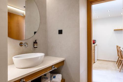 a bathroom with a white sink and a mirror at Aegean Houses in Kos Town