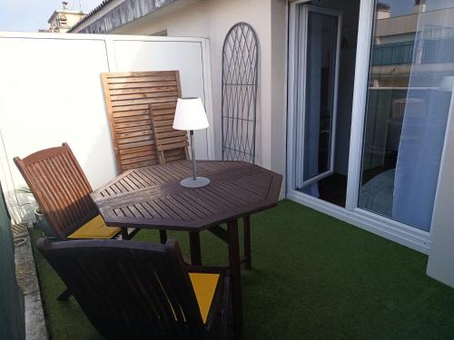 une table et des chaises sur un balcon avec une lampe dans l'établissement Studio tout confort avec terrasse, à Pau