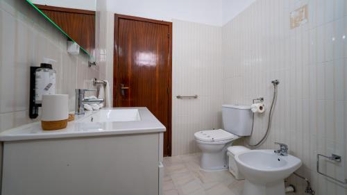 Un baño blanco con inodoro y lavabo. en Casa Conceição, en Ribeira Brava