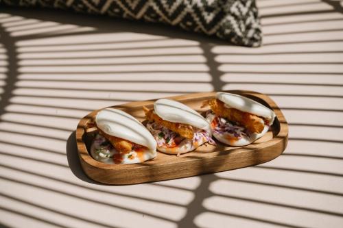 three oysters on a wooden plate on a table at Ammos Boutique Apartments & Suites in Malia