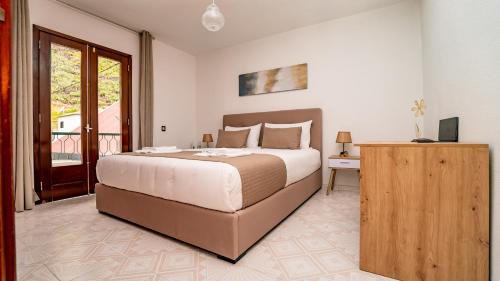 a bedroom with a large bed and a balcony at Casa Conceição in Ribeira Brava