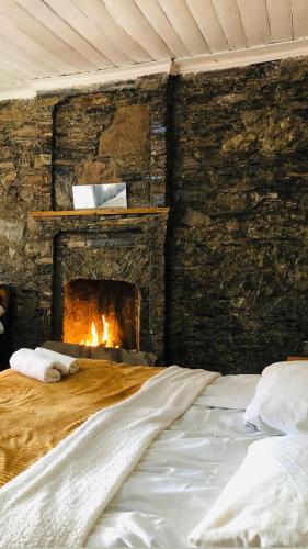 a bed in a room with a brick fireplace at Ela in Ushguli